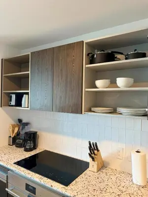a kitchen with wooden cabinets and a counter top at Sky-High Views Pool – Steps from Miami Arena in Miami