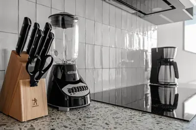 a blender sitting on top of a counter with knives at Sky-High Views Pool – Steps from Miami Arena in Miami