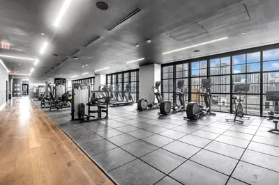 a gym with treadmills and exercise equipment in a building at Sky-High Views Pool – Steps from Miami Arena in Miami