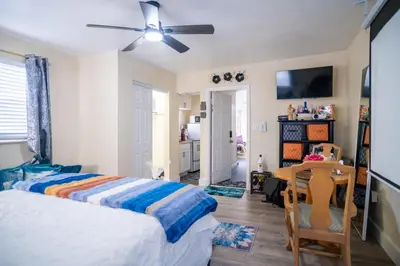 a bedroom with a bed and a table and a ceiling fan at Hidden Gem Luxe 1 BEDROOM & Patio in Cutler Bay