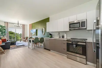 a kitchen with stainless steel appliances and a living room at New 2br 2bath 5 mins from beach 15 mins airport in Hallandale Beach