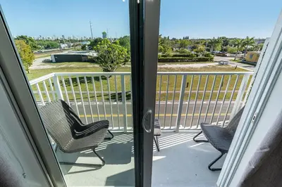 two chairs on a balcony with a view of a street at New 2br 2bath 5 mins from beach 15 mins airport in Hallandale Beach