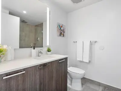 a white bathroom with a toilet and a sink at X Lounge V-Panoramic Private Residence in Miami