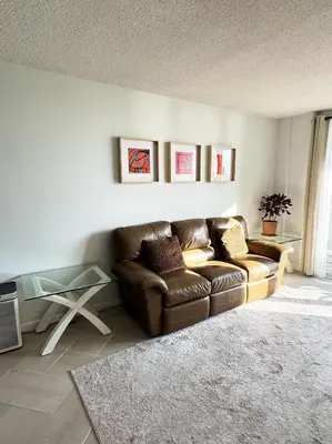 a living room with a couch and a glass table at Beachfront one bedroom in the Tides in Hollywood in Hollywood