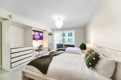 a bedroom with two beds and a television in it at Elegant Retreat Brickell in Miami