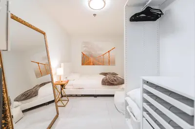 a bedroom with a bed and a mirror at Elegant Retreat Brickell in Miami