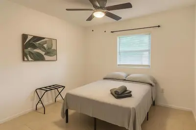 a bedroom with a bed with a ceiling fan at Fauna Bizcaya in Gold Coast Heliport