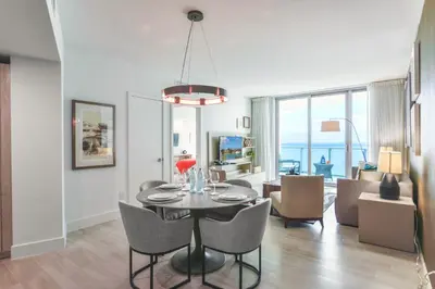 a dining room and living room with a table and chairs at Luxury Beachfront Condo W Top Amenities in Hollywood
