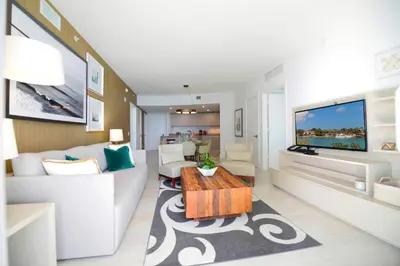 a living room with a couch and a tv at Luxury Beachfront Condo W Top Amenities in Hollywood