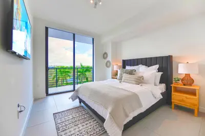 a bedroom with a bed and a large window at Beautiful and Stylish Condo Close The Doral Park in Miami