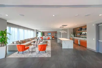 an open living room with orange chairs and a kitchen at Beautiful and Stylish Condo Close The Doral Park in Miami