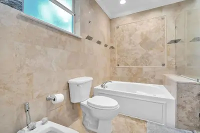 a bathroom with a toilet and a tub and a sink at Grove Walk Manor 3BR Oasis in the Grove Family in Miami