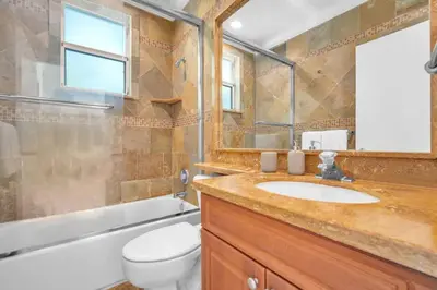 a bathroom with a sink and a toilet and a tub at Grove Walk Manor 3BR Oasis in the Grove Family in Miami