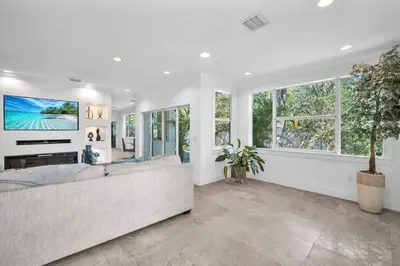 a living room with a large couch and windows at Grove Walk Manor 3BR Oasis in the Grove Family in Miami