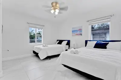 a white bedroom with two beds and a couch at Celeste House Enjoy Caribbean 2BR APT in Miami