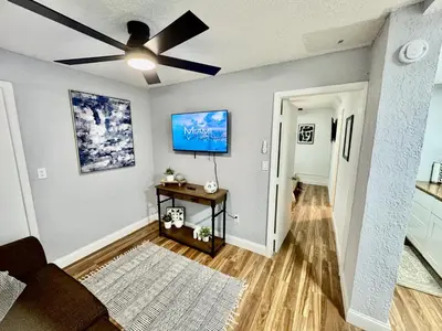 a living room with a ceiling fan and a table at Retreat in Style Private Peaceful Miami Bungalow in Olympia Heights