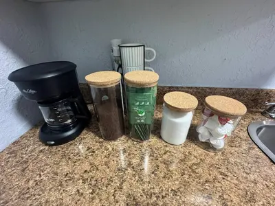 a counter top with a coffee maker and four cups at Retreat in Style Private Peaceful Miami Bungalow in Olympia Heights