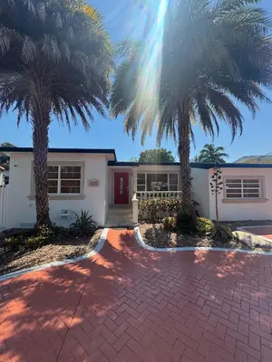 a house with two palm trees in front of it at Coral Gables Guest Studio in Miami