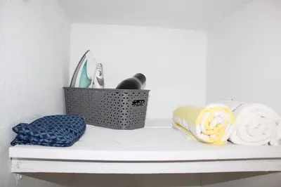 a shelf with towels and a basket on it at Coral Gables Guest Studio in Miami