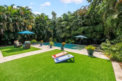 a yard with green grass and a swimming pool at The Jungalo Pool & Billards in Fort Lauderdale