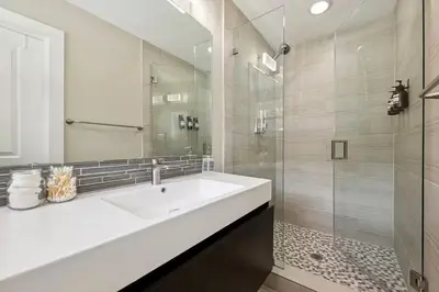 a white bathroom with a sink and a shower at The Jungalo Pool & Billards in Fort Lauderdale