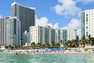 a beach with people in the water and buildings at Hollywood Beachfront Retreat in Hollywood