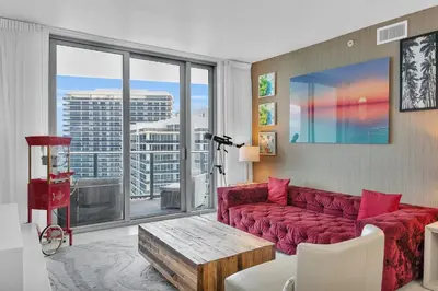 a living room with a red couch and a large window at Ventur Luxe Condo - Oceanview - Gym, Beach Access in Hollywood