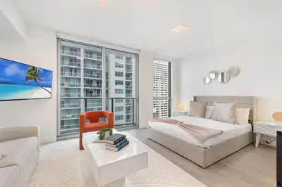 a bedroom with a bed and a large window at Designer Studio Downtown Miami with Rooftop Pool and Gym in Miami