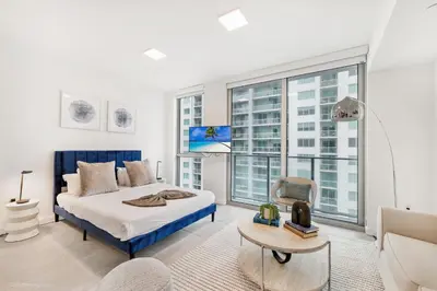 a bedroom with a king sized bed and large windows at Modern Luxe Studio in Downtown Miami with Rooftop Pool and Gym in Miami