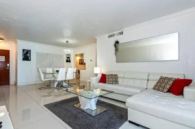 a living room with a white couch and a table at Direct access to the beach, pool and parking 3T in Hollywood
