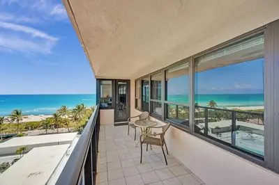 a balcony with a table and chairs and the ocean at Luxury Condo with Resort Amenities Pools Gym and Sauna 804 in Miami Beach