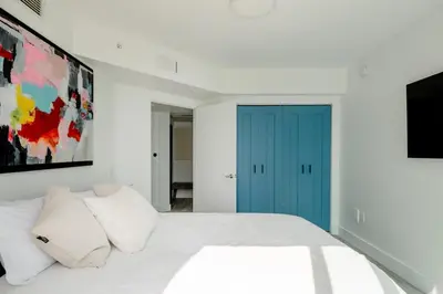 a bedroom with a bed with a blue door at LOFT Brickell River 10 min To South Beach in Miami