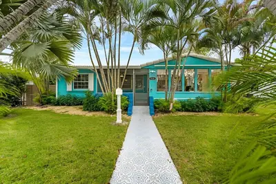 a blue house with palm trees in front of it at The Palm House in Hollywood