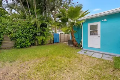 a blue house with a white door and palm trees at The Palm House in Hollywood
