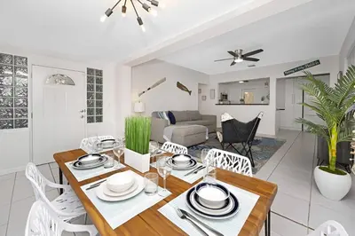 a dining room and living room with a table and chairs at The Palm House in Hollywood