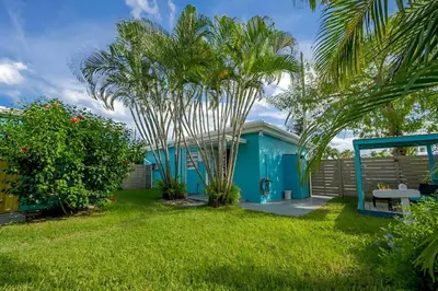 a blue house with a palm tree in the yard at Luna Beach House in Hollywood