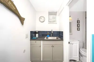 a bathroom with a sink and a clock on the wall at Blue Coral Studio in Hollywood