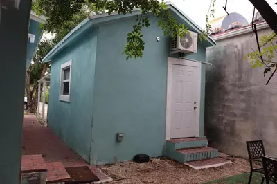 a blue building with a white door and stairs at Sunshine Studio in Dania Beach