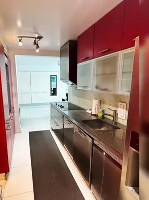 a kitchen with red cabinets and a black counter top at Ocean view-Large 2bedroom Remodeled on the beach in Hollywood