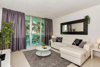 a living room with a white couch and a table at Ocean front, full equiped, pool and parking 2M in Hollywood