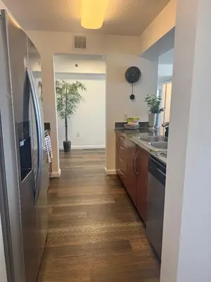 a kitchen with a stainless steel refrigerator and wooden floors at Brickell 2 bedroom condo in the heart of Miami in Miami