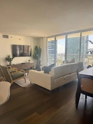 a living room with a white couch and a large window at Brickell 2 bedroom condo in the heart of Miami in Miami