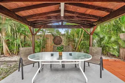 a table and chairs on a patio with a wooden ceiling at Hollywood Beach & Casino Heated Pool House in Hollywood