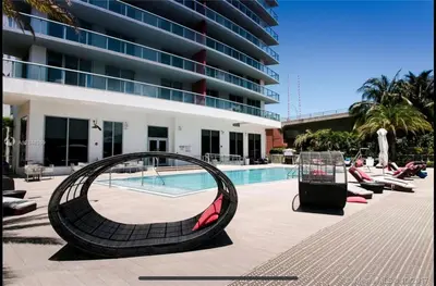 a swimming pool with a large building in the background at 2b 2b Beautiful Apmt in Hallandale Beach with beach service in Hallandale Beach