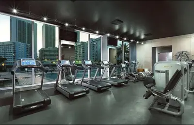 a gym with a bunch of cardio equipment in a building at Steps from the beach 2B 2B Pool, Gym, and More in Hallandale Beach