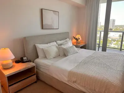 a bedroom with a white bed with a window at Apartment in Miami Beach with Kitchen, Beach Service and Gym in Hallandale Beach