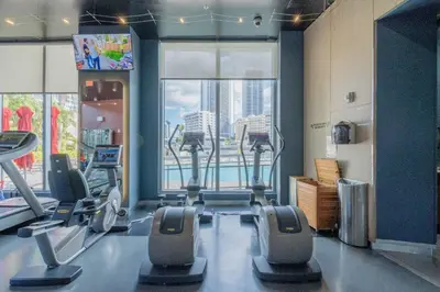 a gym with cardio equipment and a large window at Apartment in Miami Beach with Kitchen, Beach Service and Gym in Hallandale Beach