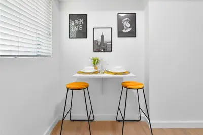 a white table with two stools in a room at Stylish Studio Near Miami Relevant Spots in Miami
