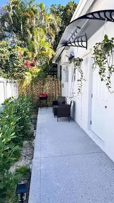 a white house with an umbrella and a patio at Miami North Beach in North Miami Beach