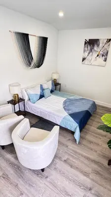 a bedroom with a large bed and a chair at Miami North Beach in North Miami Beach